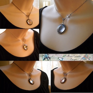 May include: A collection of necklaces with clear, oval pendants. The necklaces have different chain styles and metal finishes, including silver and bronze. The pendants are set in ornate bezels, showcasing the clear, possibly glass, center. The necklaces are displayed on a person.