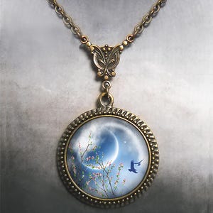 May include: A bronze necklace with a round pendant featuring a crescent moon, a branch of pink blossoms, and a blue bird flying against a blue sky.