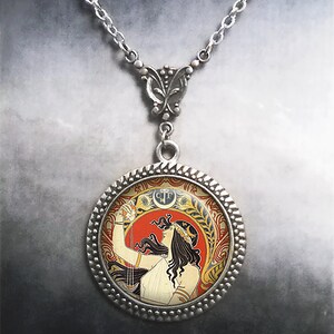 May include: A silver necklace with a round pendant featuring a vintage illustration of a woman in a white dress holding a glass of wine. The pendant has a decorative silver border.