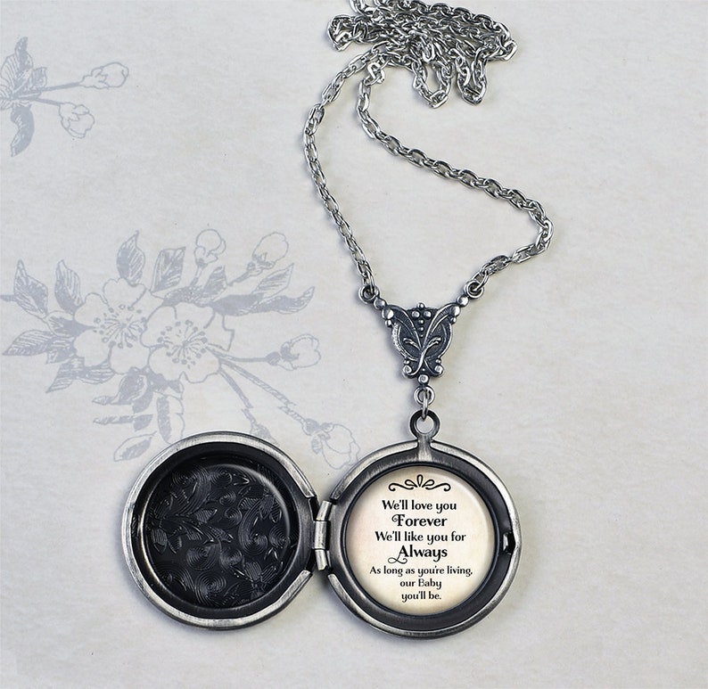 May include: Silver locket necklace with a delicate chain. The locket opens to reveal a message that reads: "We'll love you Forever We'll like you for Always As long as you're living, our Baby you'll be."
