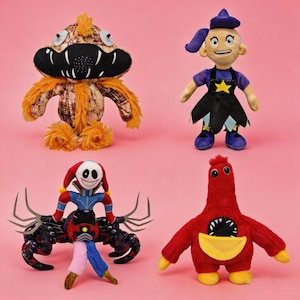 Pode incluir: Quatro brinquedos de pelúcia coloridos em um fundo rosa. Os brinquedos incluem um monstro marrom e laranja, uma bruxa com chapéu e vestido roxos, um palhaço montado em uma aranha e uma criatura vermelha com uma bolsa amarela.