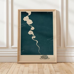 May include: A framed wall art print featuring a dark teal background with a vertical trail of cream-colored stylized clouds. At the bottom, a small gray cat is curled up asleep on a cream-colored cushion. The text Pretty Blue Prints is visible.