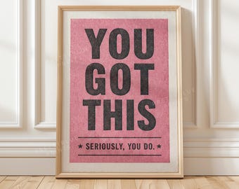 Könnte beinhalten: Ein gerahmter Kunstdruck mit einem strukturierten rosa Hintergrund und fettgedrucktem schwarzem Text, der YOU GOT THIS und darunter SERIOUSLY, YOU DO lautet, eingerahmt von zwei horizontalen Linien mit einem Stern auf jeder Seite.
