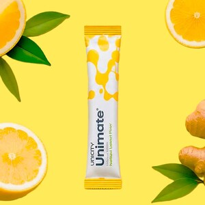 K&ouml;nnte beinhalten: Ein wei&szlig;es Unimate-P&auml;ckchen mit gelben Mustern und dem Text "Unicity Unimate Nootropic Lemon Flavor" auf gelbem Hintergrund. Zitronenscheiben, gr&uuml;ne Bl&auml;tter und ein St&uuml;ck Ingwer sind ebenfalls vorhanden.