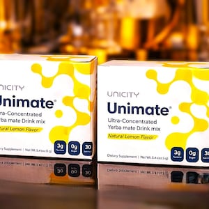 K&ouml;nnte beinhalten: Zwei Unicity Unimate-Boxen. Die Boxen sind wei&szlig; mit gelben abstrakten Designs und dem Text "Unimate" in Blau. Die Boxen enthalten auch "Ultra-Concentrated Yerba mate Drink mix" und "Natural Lemon Flavor". Jede Box enth&auml;lt 3g Yerba Mate.