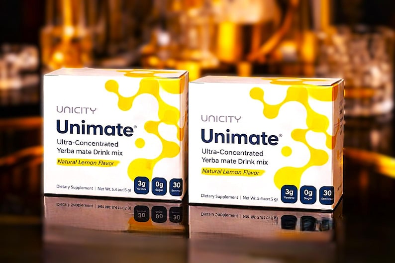 K&ouml;nnte beinhalten: Zwei Unicity Unimate-Boxen. Die Boxen sind wei&szlig; mit gelben abstrakten Designs und dem Text "Unimate" in Blau. Die Boxen enthalten auch "Ultra-Concentrated Yerba mate Drink mix" und "Natural Lemon Flavor". Jede Box enth&auml;lt 3g Yerba Mate.