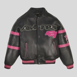 May include: Black leather jacket with pink accents. The jacket features the text "Avirex" across the chest and the number "4" in pink. Pink stripes adorn the sleeves and the ribbed collar and cuffs are also pink.