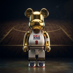 Pu&ograve; includere: Una statuetta da collezione a forma di orso color oro che indossa una canotta da basket bianca con la scritta USA BASKETBALL e il numero 9 sul davanti. La statuetta ha un polsino bianco sul braccio sinistro e scarpe bianche con dettagli neri e rossi.