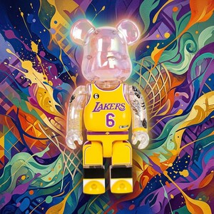Pu&ograve; includere: Una statuetta da collezione traslucida a forma di orso che indossa una maglia da basket gialla dei Los Angeles Lakers con il numero 6 stampato sul davanti. La figura presenta testa e braccia trasparenti, gambe gialle e dettagli neri sui piedi.