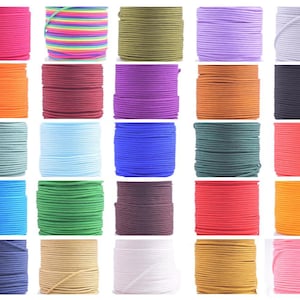 May include: Assortment of 25 spools of colourful elastic cord. The cords are arranged in five rows of five spools each. The colours include red, orange, yellow, green, blue, purple, pink, brown, black, white, and grey.