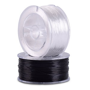 May include: Two spools of filament for 3D printing. One spool is clear and the other is black.