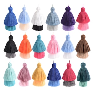 May include: Assortment of 18 two-toned tassel charms in various colors, including blue, pink, red, green, brown, orange, white, and black. The tassels are made of yarn and have a double layer.