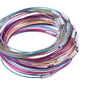 May include: A stack of colorful metal wire necklaces with silver clasps. The necklaces are arranged in a circle, with the clasps facing outwards.