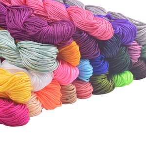 Puede incluir: Una colección de cordones de colores, incluyendo rosa, amarillo, verde, azul y morado, dispuestos en forma de abanico.