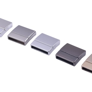 Peut inclure: Cinq fermoirs magnétiques rectangulaires aux finitions métalliques variées : argent, canon de fusil et or. Les fermoirs sont disposés en diagonale sur un fond blanc, mettant en valeur leur design élégant et moderne. Ces fermoirs sont probablement utilisés pour des bijoux ou des accessoires.