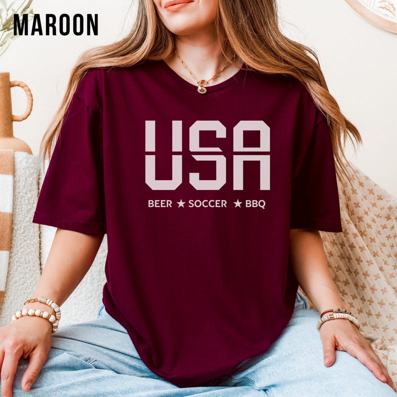 maroon USA T-shirt for Soccer Fans featuring bold block letters and ‘Beer Soccer BBQ’ slogan, patriotic graphic tee for World Cup 2026 and game day wear.