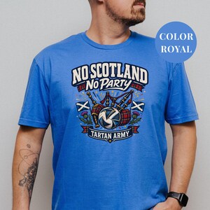 A man wearing a blue t-shirt with a graphic design that says "NO SCOTLAND NO PARTY TARTAN ARMY".