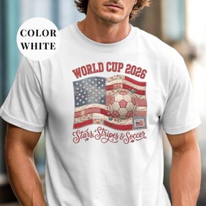 White colored t-shirt featuring a vintage patchwork American flag design for World Cup 2026. The faux quilted graphic includes floral and gingham fabric textures, a stitched soccer ball, and "Stars, Stripes & Soccer" text. Unique patriotic sports apparel for women and USA soccer fans.