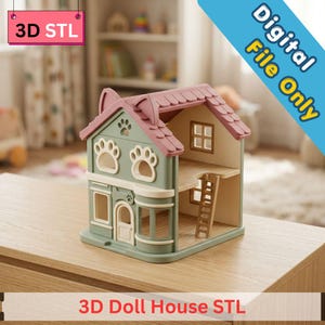 May include: A two-story doll house with a sage green exterior, a pink roof with cat ear accents, and paw-shaped windows. The structure features a central door, a side bay window, and an internal ladder. Text reads 3D STL and Digital File Only.