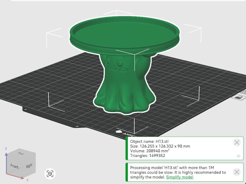 Pu&ograve; includere: Un modello 3D verde di un supporto a piedistallo con piano circolare e una base che presenta un volto stilizzato. L'interfaccia software mostra il nome dell'oggetto H13.stl, dimensioni di 126,255 x 126,332 x 90 mm, un volume di 208940 mm3 e 1499352 triangoli.