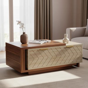 May include: A modern coffee table with a two-tone design. The top is a dark wood, with a lighter wood section. The front features two doors with a chevron pattern. Gold-colored handles and a brown vase with flowers are on top.