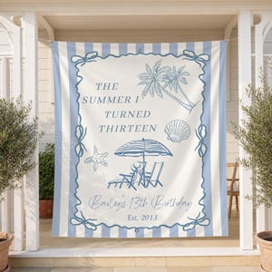 May include: A rectangular fabric banner with light blue and white vertical stripes featuring a central cream panel. The text reads THE SUMMER I TURNED THIRTEEN, Bailey's 13th Birthday, and Est. 2013, accompanied by illustrations of palm trees, a seashell, a starfish, and beach chairs under an umbrella.