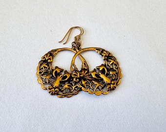 May include: Gold tone filigree earrings with a floral and bird design.