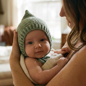 Puede incluir: Una taza de cerámica blanca con asa negra y el texto "But First, Coffee" en negrita negra. La taza se encuentra sobre un fondo borroso, sugiriendo un ambiente acogedor.
