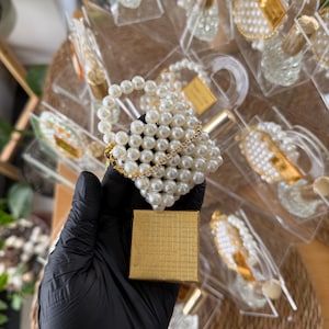 Handcrafted mini pearl bag keychain included in a clear acrylic purse favor box for bridal shower gifts