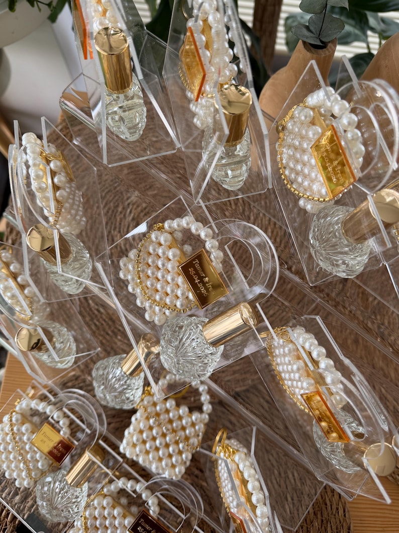 Bulk order of personalized luxury plexi purse favors with pearls and glass bottles for high-end events