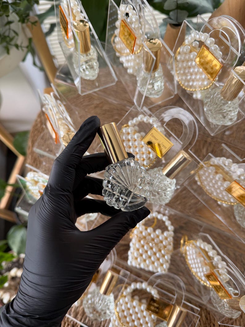Luxury glass cologne bottle with gold cap inside a personalized clear favor box for elegant weddings