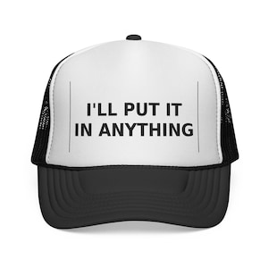 May include: A black and white trucker hat featuring the text "I'LL PUT IT IN ANYTHING". The hat has a white front panel, a black peak, and a black mesh back, suitable for various casual occasions.