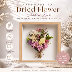 May include: A handmade 22cm x 22cm shadow box with a 3D arrangement of real dried flowers in pink, yellow, and green. The wooden frame surrounds the floral display, with text that reads "Dried Flower Shadow Box".