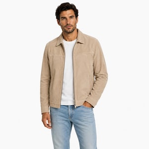 Può includere: Una giacca in camoscio beige con colletto classico, chiusura frontale con zip intera e cuciture orizzontali sul petto. La giacca è indossata sopra una t-shirt bianca semplice e jeans in denim azzurro, con maniche lunghe.