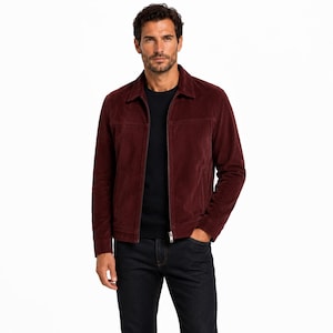 Peut inclure: Une veste en daim bordeaux profond dotée d'un col classique, d'une fermeture éclair intégrale sur le devant et de coutures horizontales sur la poitrine. La veste est portée sur un t-shirt noir à col rond et un jean en denim foncé.