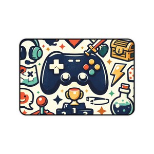 May include: Rectangular gaming mousepad with a navy blue game controller at the center, surrounded by colorful gaming-themed illustrations. Includes a trophy, lightning bolt, potion bottle, and other icons. The background is off-white.