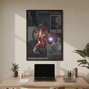 K&ouml;nnte beinhalten: Gerahmtes Iron Man-Poster mit dem Superhelden im Flug, mit einem rot-goldenen Anzug und einer leuchtenden Hand. Das Poster enth&auml;lt die W&ouml;rter "HERO", "IRON MAN" und "STARK". Das Poster wird &uuml;ber einem Holztisch mit einem Laptop und Zubeh&ouml;r angezeigt.