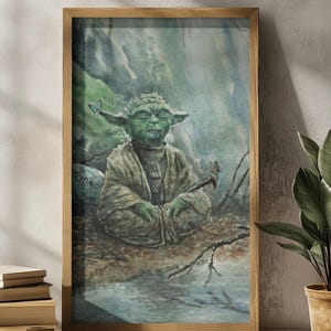 Op de afbeelding: Aquarel schilderij van Yoda uit Star Wars, ingelijst in een lichtbruine houten lijst. Yoda wordt afgebeeld in een meditatieve pose, met vlinders die op zijn oor en staf rusten. De achtergrond toont een serene bosscène.