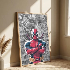 May include: Framed poster featuring Deadpool in a red and black suit, arms crossed, with swords on his back. The background is a collage of comic book panels in black and white. The frame is a light wood color.