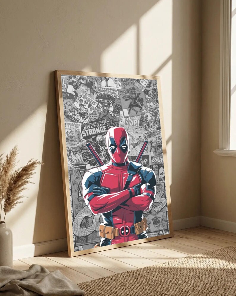 May include: Framed poster featuring Deadpool in a red and black suit, arms crossed, with swords on his back. The background is a collage of comic book panels in black and white. The frame is a light wood color.