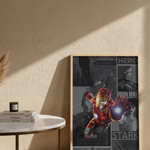 K&ouml;nnte beinhalten: Gerahmtes Poster mit Iron Man in dynamischer Pose, in einem rot-goldenen Anzug, mit leuchtender Hand. Der Hintergrund zeigt Comic-Panels in Graustufen mit den Worten "HERO", "IRON MAN" und "STARK". Das Poster h&auml;ngt an einer Wand.