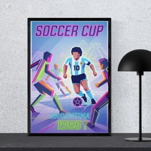 May include: Framed poster with a soccer theme. The artwork features a player in a light blue and white uniform with the number 10, kicking a soccer ball. The words "SOCCER CUP" and "ARGENTINA 1986" are displayed in the image.