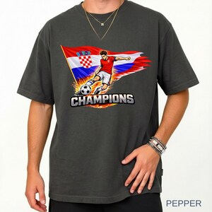 A person wearing a pepper t-shirt with a graphic design depicting a soccer player kicking a soccer ball, along with a flag of Croatia.