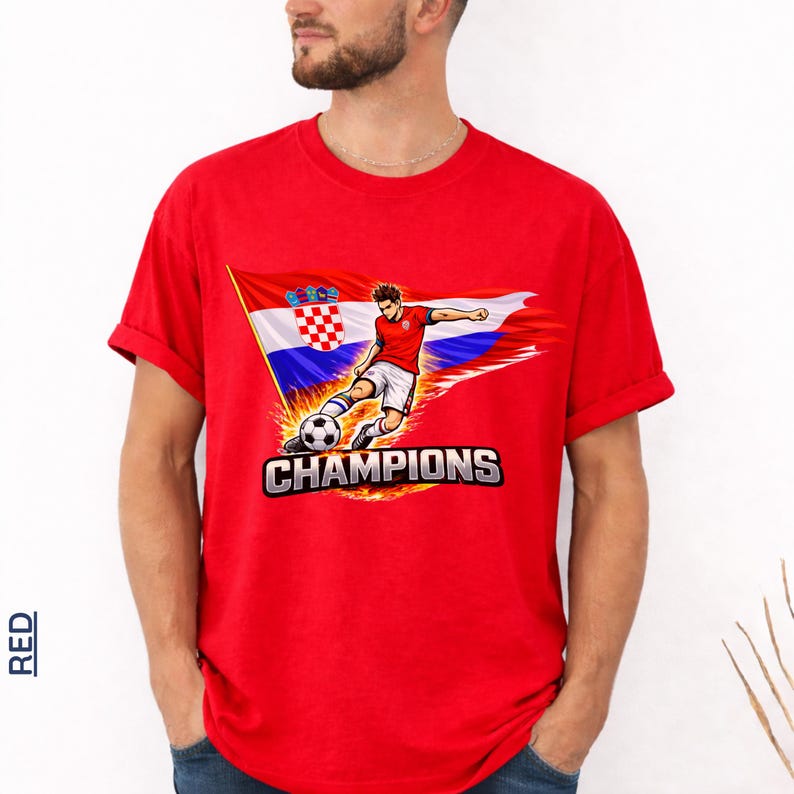 A man wearing a red t-shirt with a graphic of a soccer player kicking a ball and the text "CHAMPIONS" printed on it.