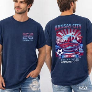 A navy back print shirt the front features a minimal "SOCCER CUP 26 KANSAS CITY" logo.