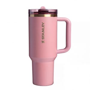 May include: A pink Stanley insulated tumbler with a handle and a clear lid. The tumbler has the Stanley logo printed on the side. The tumbler is designed to keep beverages hot or cold for hours.
