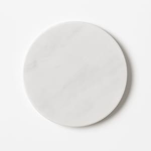 May include: A round, white marble coaster with subtle gray veining. The coaster is circular and has a smooth surface. This elegant coaster is suitable for use with glasses and mugs.