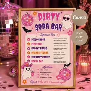 Könnte beinhalten: Ein rechteckiges Schild in einem goldenen Rahmen mit der Aufschrift Dirty Soda Bar auf einem rosa karierten Hintergrund. Es zeigt Illustrationen von Geistern, Discokugeln, Fledermäusen und Blumen. Der Text listet Getränke und Zutaten auf.