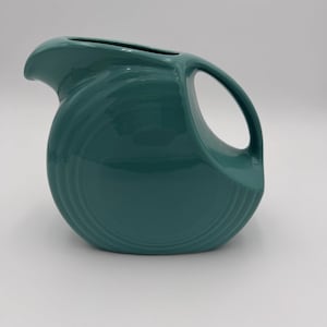 May include: A set of three ceramic mugs with a speckled, matte finish. The mugs are in shades of cream, light gray, and dark gray. Each mug has a simple, minimalist design and a rounded handle.