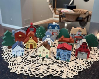 Miniatura vintage de arte folclórica pintada à mão em madeira, representando uma vila rural americana.